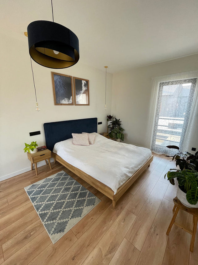 Granatowe łóżka tapicerowane jako modne wyposażenie wnętrz